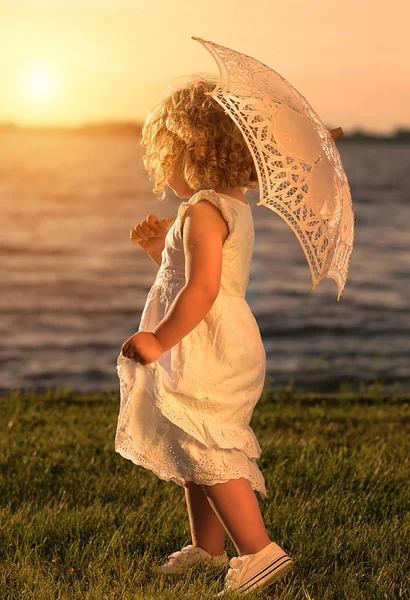 Young beautiful girl posing for the camera at sunset — Stock Photo, Image