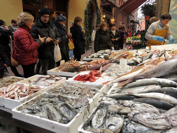 Multidão de pessoas em frente a um stand de peixe fresco no mercado ao ar livre para fazer compras — Fotografia de Stock