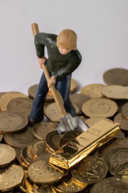 Endüstriyel Mühendislik işçisi altın külçesi ve madeni parayla iş ve endüstri konsepti kazıyor. Altın, gümüş, bronz madeni para ile para kazanmak için çok çalışmak gibi.