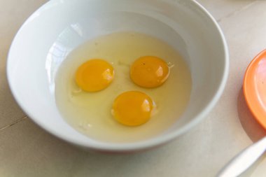 Beyaz bir kasede üç yumurta.