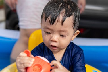 tapılası erkek bebek mutlu ve mini havuzda su oynamaktan zevk alıyor.