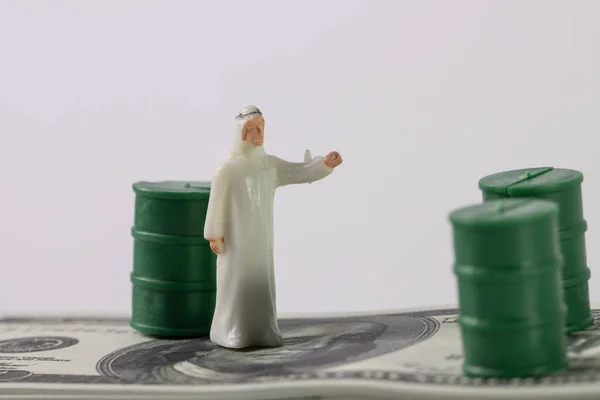 Stack Image of Arab Saudi man with USD noted with oils barrel. Crude oil commodity trading in price crisis situation.