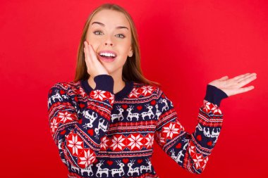 Noel süveteri giyen çılgın genç beyaz kız indirimli fiyatlar öneriyor.