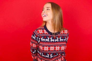 Kafkasyalı genç kız Noel süveteri giyiyor. Yeni planlar için çok mutlu ve heyecanlı..