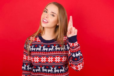 Kırmızı arka planda Noel süveteri giyen beyaz kız Çince işaret diliyle 