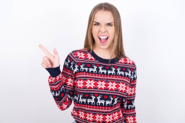 Beyaz arka plan noktalarında beyaz süveter giyen beyaz tenli genç bir kız fotokopi boşluğunda. İnsanlar tanıtım ve reklam kavramları