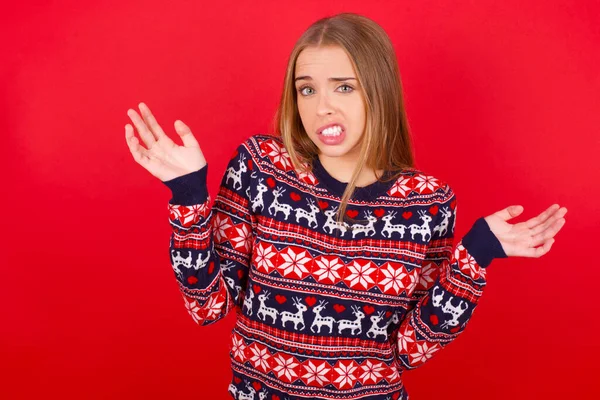 Nieświadoma Młoda Kaukaska Dziewczyna Nosząca Świąteczny Sweter Wzrusza Ramionami Wahaniem — Zdjęcie stockowe