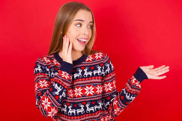 Funny Young Caucasian Girl Wearing Christmas Sweater Holding Open Palm — Stock Photo, Image