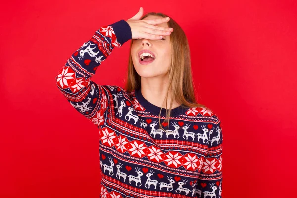 Kırmızı Arka Planda Noel Süveteri Giyen Genç Beyaz Bir Kız — Stok fotoğraf