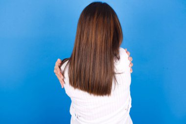  Güzel, genç bir kadın, mutlu ve pozitif bir şekilde kendini kucaklıyor. Sevgi ve özgüven.