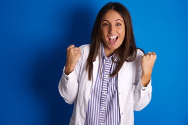  Güzel Latin kadın şaşırmış ve şaşırmış bir şekilde kollarını kaldırarak ve gözlerini açarak kutluyor. Kazanan konsept.