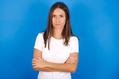 Kasvetli, tatminsiz, güzel, Latin bir kadın, alnının altından zavallı bir ifadeyle, suratını buruşturuyor.