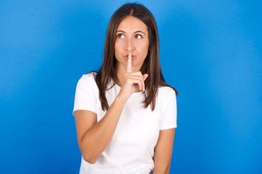  Güzel Latin kadın sessizlik jesti işaret parmağını dudaktan ayırmaz. Sırrımızı paylaşmamamızı istiyor.