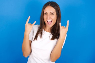  Güzel Latin kadın rock n roll tabelasını kendinden emin ve neşeli gösteriyor. Partide havalı müzikten hoşlanıyor. Vücut dili kavramı.