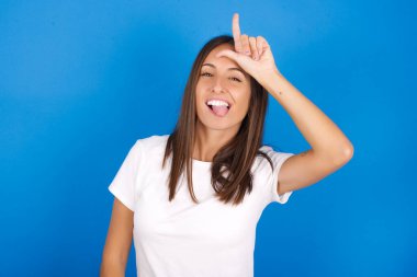 Alnında parmak olan güzel genç bir kadın jestleri kaybedenlerin jestlerini yapar. İnsanlar dil gösterir.