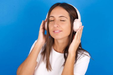 Kafasında kulaklıklarla güzel bir genç kadın müzik dinliyor. Gözü kapalı en sevdiği şarkıyı dinliyor. Kulaklıkla el ele tutuşuyor..