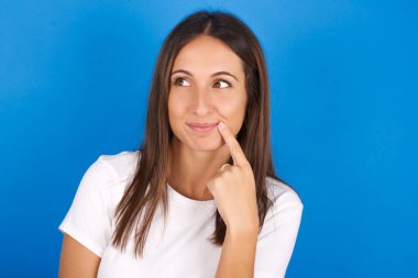 Güzel, rüya gibi genç bir kadın parmaklarını dudaklarına yaklaştırıyor..