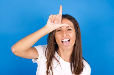 Komik, güzel genç bir kadın ezik bir jest yapıyor. Birine gülüyor, dili dışarı çıkıyor, suratını buruşturuyor..