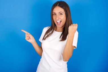 Güzel genç kadın boş yeri işaret ediyor. Yumruğunu kaldır, kazanan jest..