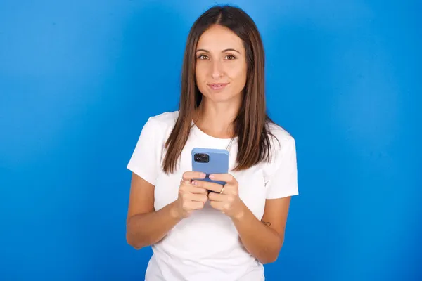 Retrato Una Joven Joven Confiada Seria Sosteniendo Teléfono Dos Manos —  Fotos de Stock