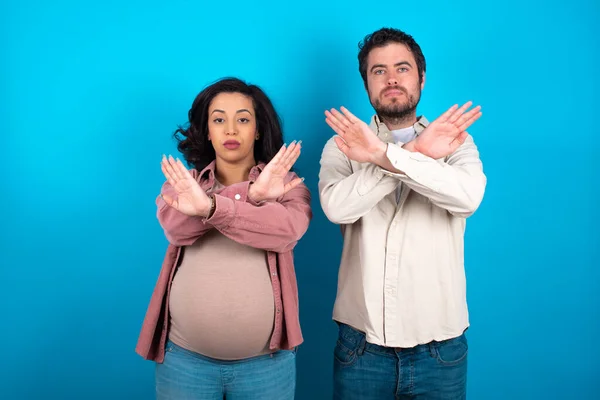 Jovem Casal Esperando Bebê Contra Fundo Azul Tem Expressão Rejeição — Fotografia de Stock