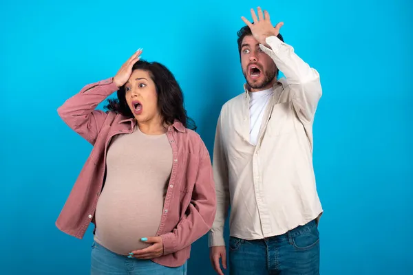 Junges Paar Erwartet Ein Baby Steht Vor Blauem Hintergrund Überrascht — Stockfoto