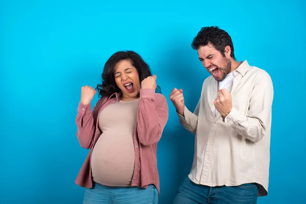 Junges Paar Erwartet Ein Baby Vor Blauem Hintergrund Sehr Glücklich — Stockfoto