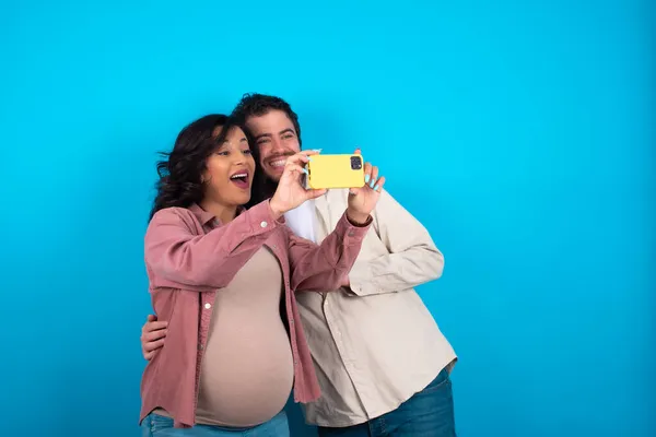 Jovem Casal Esperando Bebê Contra Fundo Azul Tomar Uma Selfie — Fotografia de Stock