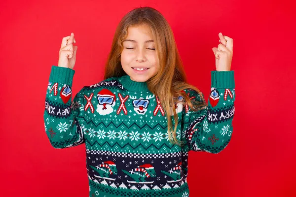 Joyful Brunette Kid Girl Knitted Sweater Christmas Red Background Clenches — Stock Photo, Image