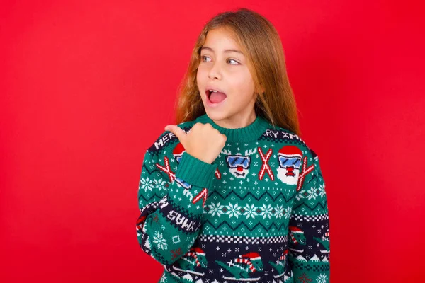 Stupefied Brunette Kid Girl Knitted Sweater Christmas Red Background Surprised — Stock Photo, Image