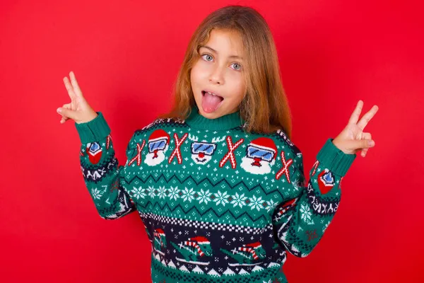 Brunette Kid Girl Knitted Sweater Christmas Red Background Optimistic Smile — Stock Photo, Image