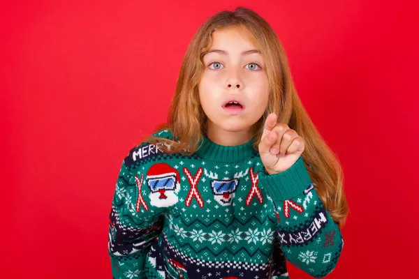 Petite Fille Brune Choquée Pull Tricoté Noël Sur Fond Rouge — Photo