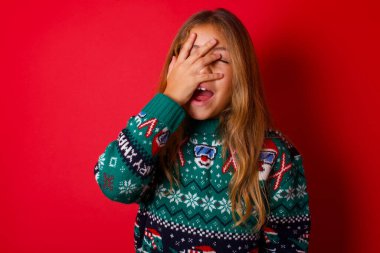 Karizmatik, kaygısız, neşeli esmer kız. Kırmızı arka planda örgü örmüş süveter giyen kız. Gülüşmeler, kıkırdamalar, kahkahalar..