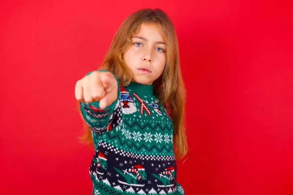 陽気なブルネットの子供の女の子でニットセータークリスマス以上の赤の背景はあなたに幸せを示し 競争することを選択し 正の式を持っている 選択を行います — ストック写真