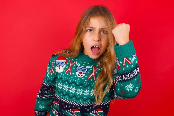 Fierce Brunette Kid Girl Knitted Sweater Christmas Red Background Holding — Stock Photo, Image
