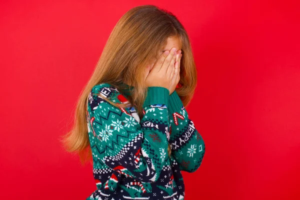 Triste Niña Morena Jersey Punto Navidad Sobre Fondo Rojo Cubriendo —  Fotos de Stock