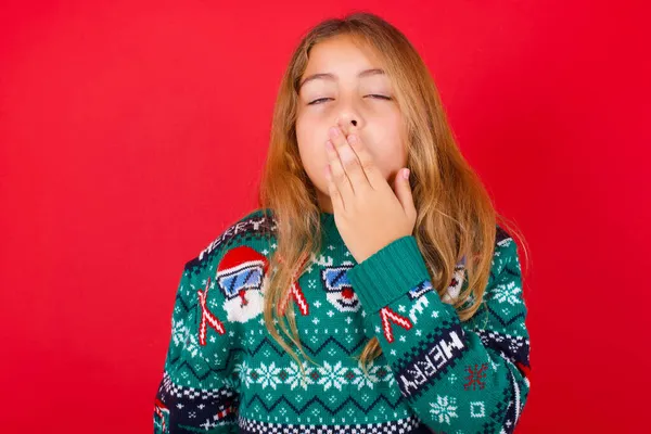 Sleepy Brunette Kid Girl Knitted Sweater Christmas Red Background Yawning — Stock Photo, Image