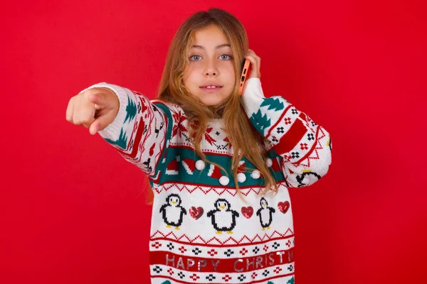 Позитивна Дівчинка Брюнетки Язаному Светрі Різдво Червоному Тлі Вказує Безпосередньо — стокове фото