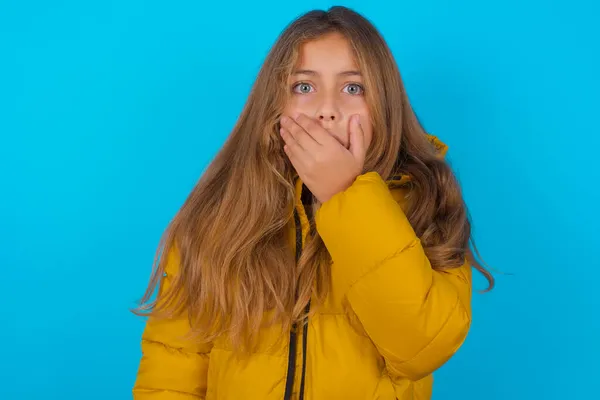 Emotional Brunette Kid Girl Wearing Yellow Jacket Blue Background Gasps — Stock Photo, Image