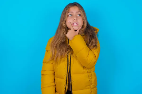 Menina Morena Criança Vestindo Casaco Amarelo Sobre Fundo Azul Pensando — Fotografia de Stock