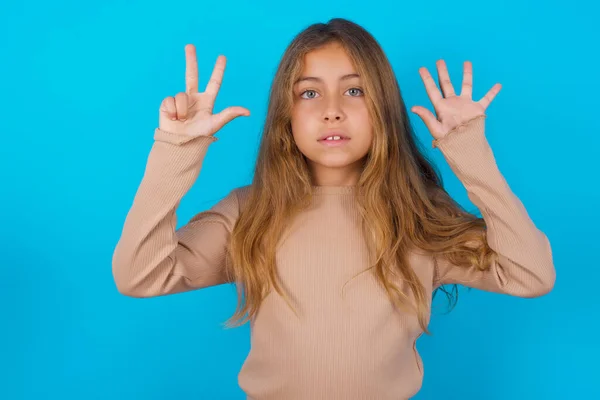 Brunetka Dziecko Dziewczyna Noszenie Sweter Niebieskim Tle Pokazując Wskazując Palce — Zdjęcie stockowe