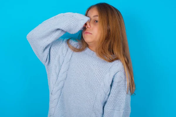 Niña Morena Vistiendo Suéter Punto Azul Sobre Fondo Azul Oliendo —  Fotos de Stock