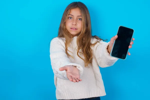 Brünettes Mädchen Weißem Strickpullover Vor Blauem Hintergrund Mit Handy Smartphone — Stockfoto