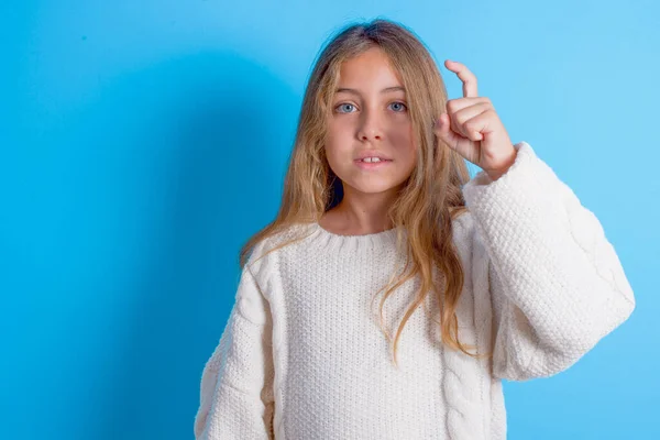 Niña Morena Usando Suéter Punto Blanco Sobre Fondo Azul Apuntando —  Fotos de Stock