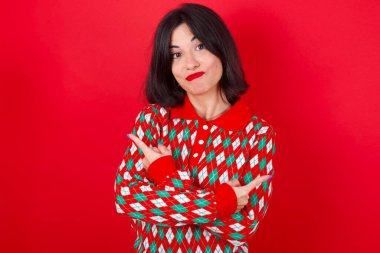 Kızıl arka planda örgü kazak giyen esmer beyaz kız kollarını kavuşturuyor ve farklı taraflardan iki farklı nesne ya da varyant arasında tereddüt ediyor. Karar vermede yardıma ihtiyacı var