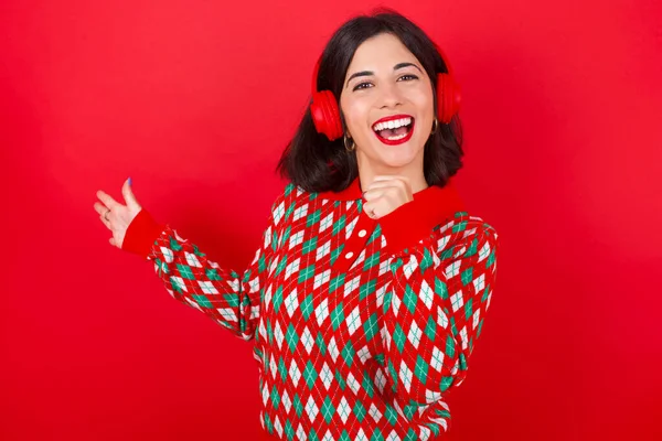 Glückliches Brünettes Kaukasisches Mädchen Strickpullover Weihnachten Vor Rotem Hintergrund Singt — Stockfoto