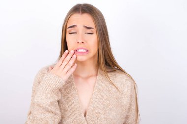 manken acı dolu ifadeyle ağıza dokunuyor. 