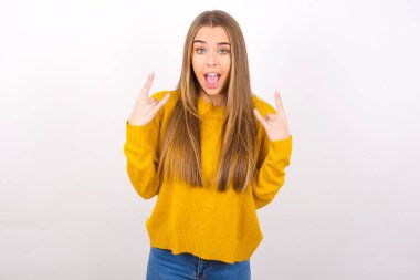 Genç bir kadın açık ağızla taş hareketleri yapıyor.