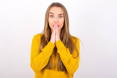 Korkmuş genç bir kadın. Gözleri açık, elleri yüzü açık.