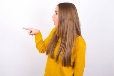 Şaşırmış genç bir kadın parmağıyla işaret ediyor.